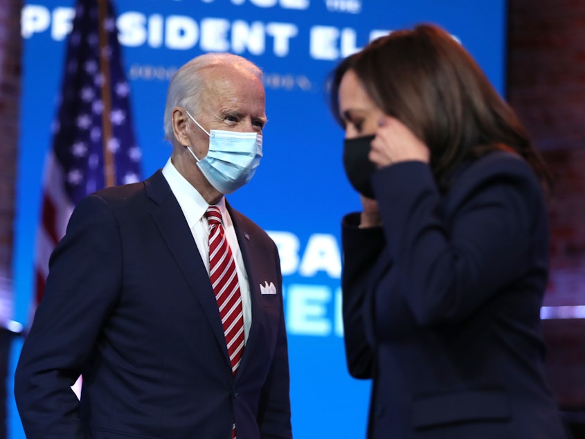 caption: President-elect Joe Biden walks by Vice President-elect Kamala Harris before delivering remarks on his plan for economic recovery under his incoming administration.