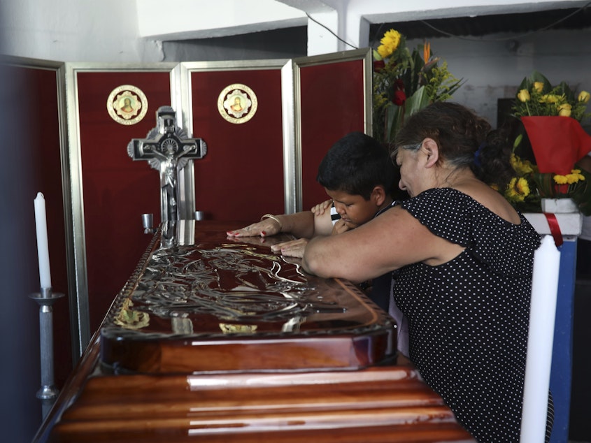 caption: Twelve-year-old Jesús Ruiz grieves as he stands before the coffin containing the remains of his father, Mexican journalist Jorge Celestino Ruiz Vazquez, in Actopan, Veracruz, on Aug. 3. The Committee to Protect Journalists said Ruiz Vazquez was the third journalist killed in a single week in Mexico.