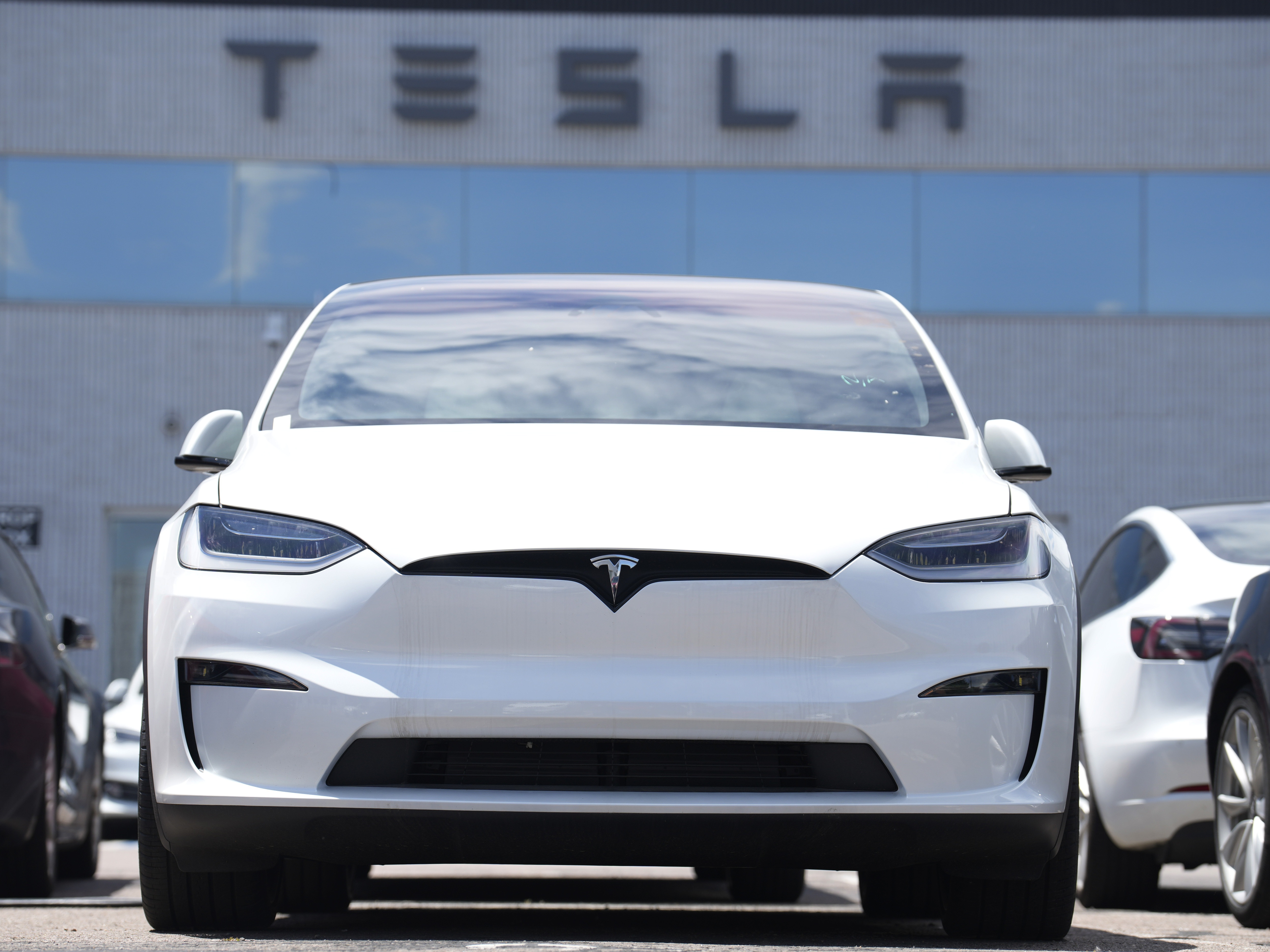 caption: A 2023 Model X sports-utility vehicle sits outside a Tesla dealership Sunday, June 18, 2023, in Englewood, Colo.