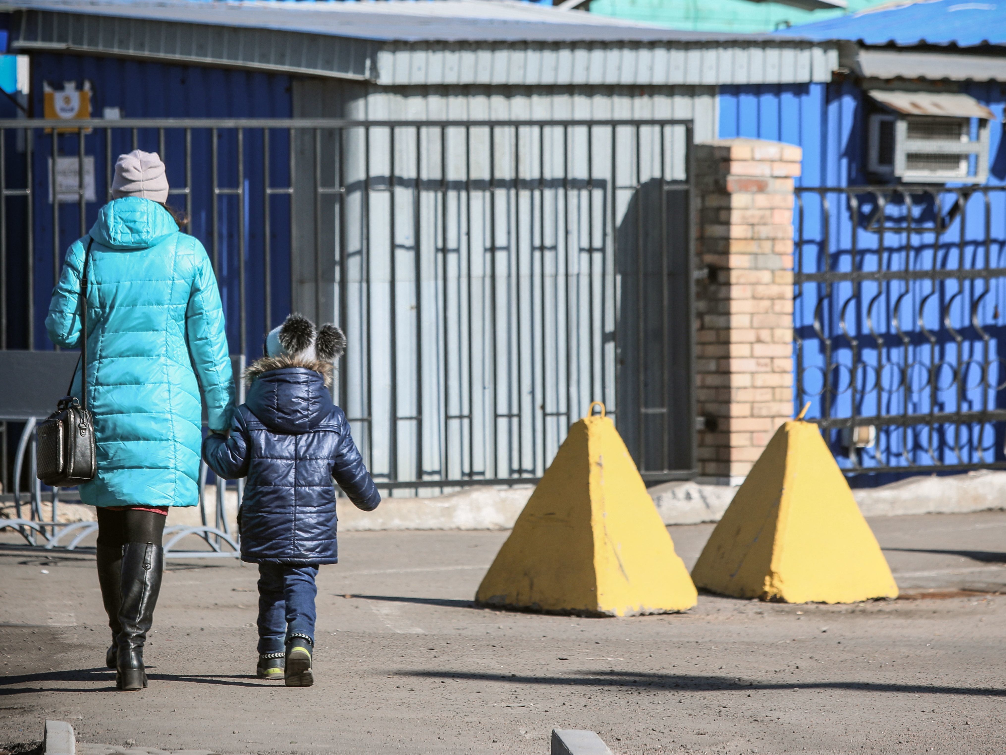 caption: People walk past anti-tank barriers in the town of Avdiivka, on the eastern Ukraine front-line with Russia-backed separatists. The Ukrainian government said separatists have sharply increased their shelling attacks in the eastern part of the country.