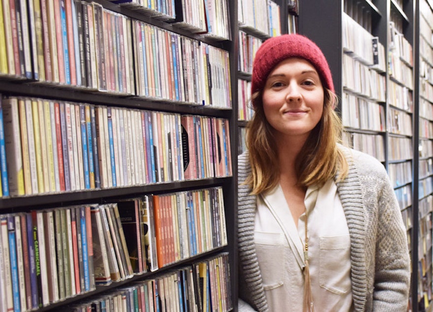 caption: Brandi Carlile among the music collection at the KUOW studios.