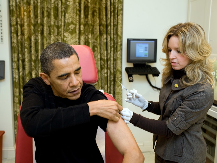 caption: A White House nurse prepares to administer the H1N1 vaccine to then-President Barack Obama at the White House on Dec. 20, 2009. On Friday, President Trump called the Obama administration's response to that outbreak "a full scale disaster."