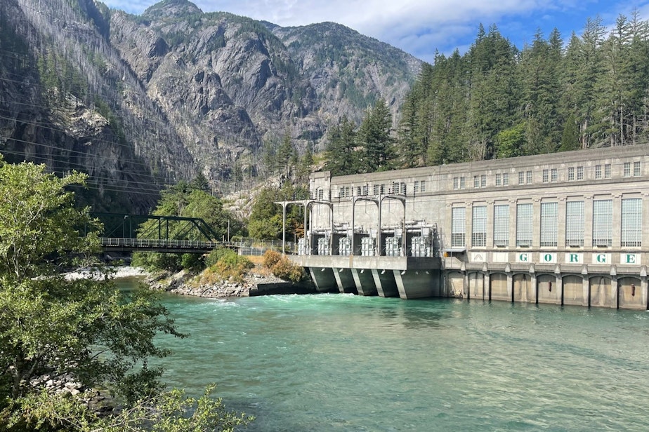 caption: The Gorge Dam powerhouse on the Skagit River, just west of the Sourdough Fire, on Aug. 8, 2023.