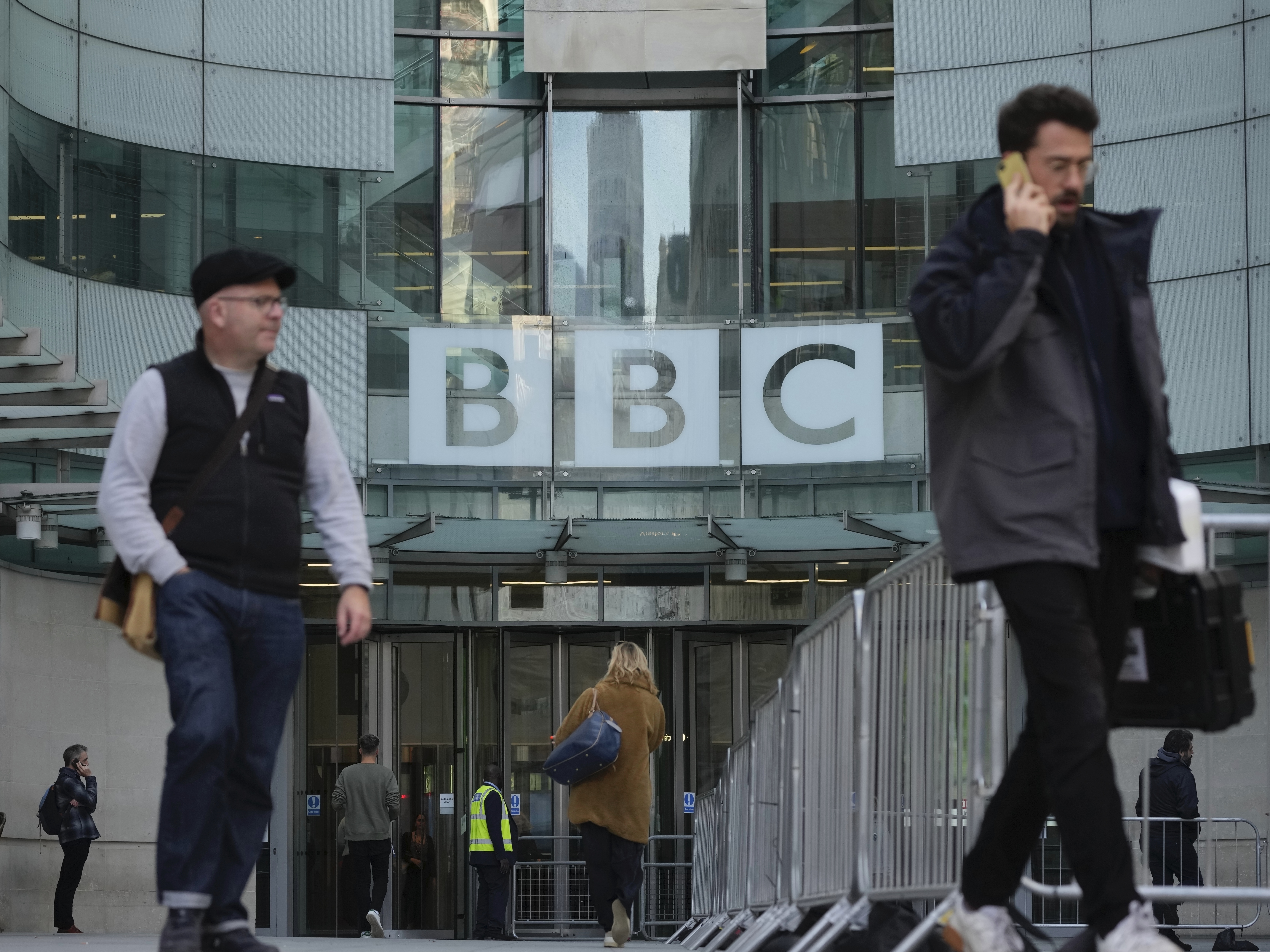 caption: People walk past the BBC Headquarters in London on Tuesday as the BBC is celebrating 100 years of broadcasting.