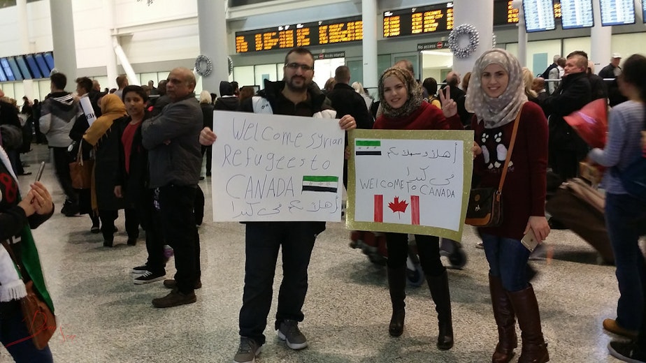 caption: People welcome Syrian refugees at the Toronto airport on Dec. 9, 2015.