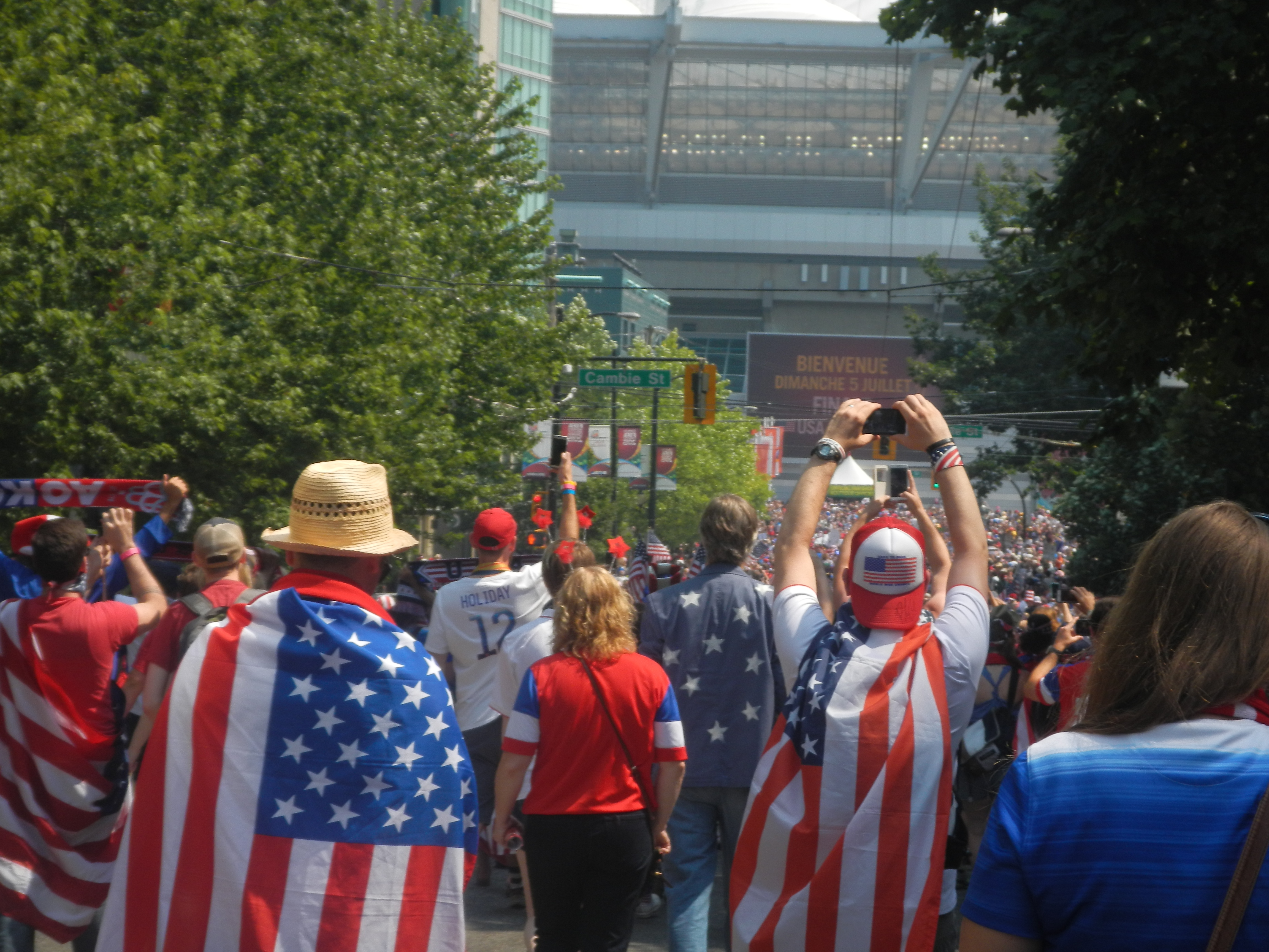 caption: American fans march fill the street as they march to the final match at BC Place.