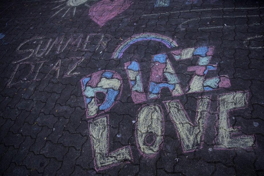 caption: Chalk drawings are shown next to a memorial for Summer Taylor and Diaz Love on Wednesday, July 22, 2020, at City Hall Park in Seattle. 