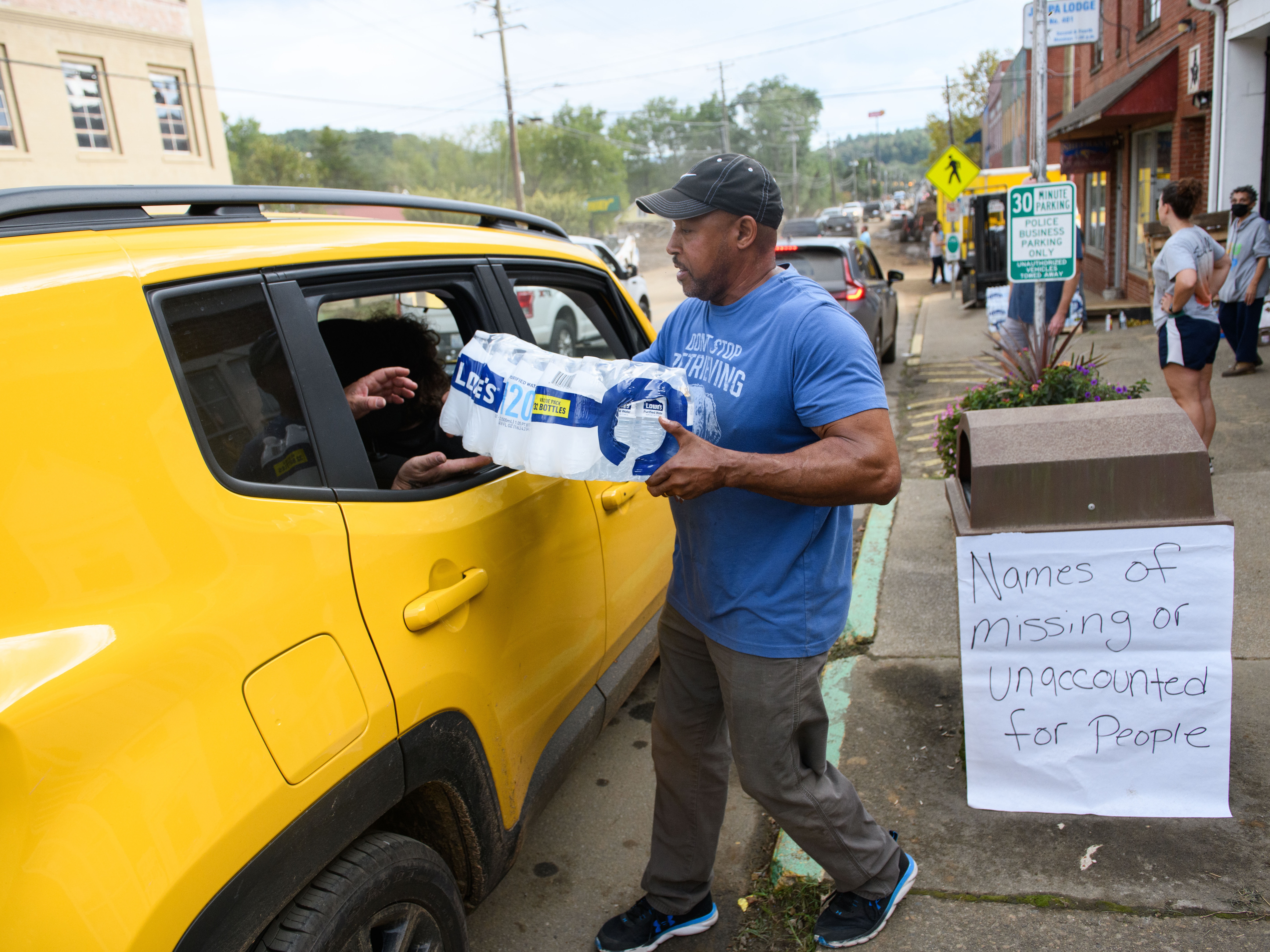 caption: Tony J. Daniel hands out bottled water in the aftermath of Hurricane Helene on Sunday in Old Fort, N.C.