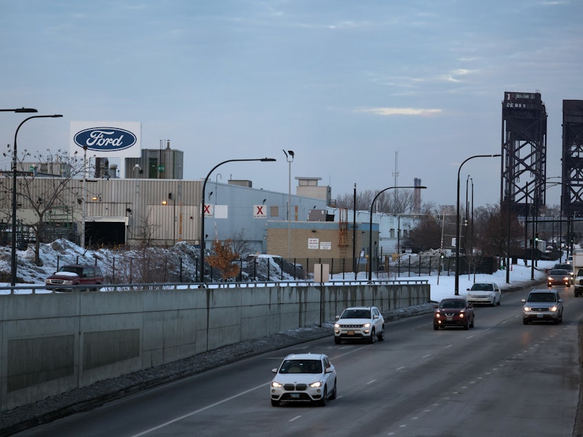 caption: The Ford company logo is displayed above the Chicago Assembly Plant on Feb. 3. Ford is allowing many workers to work remotely — not just during the pandemic, but as routine policy. But of course, plant workers can't sign in to work from home.