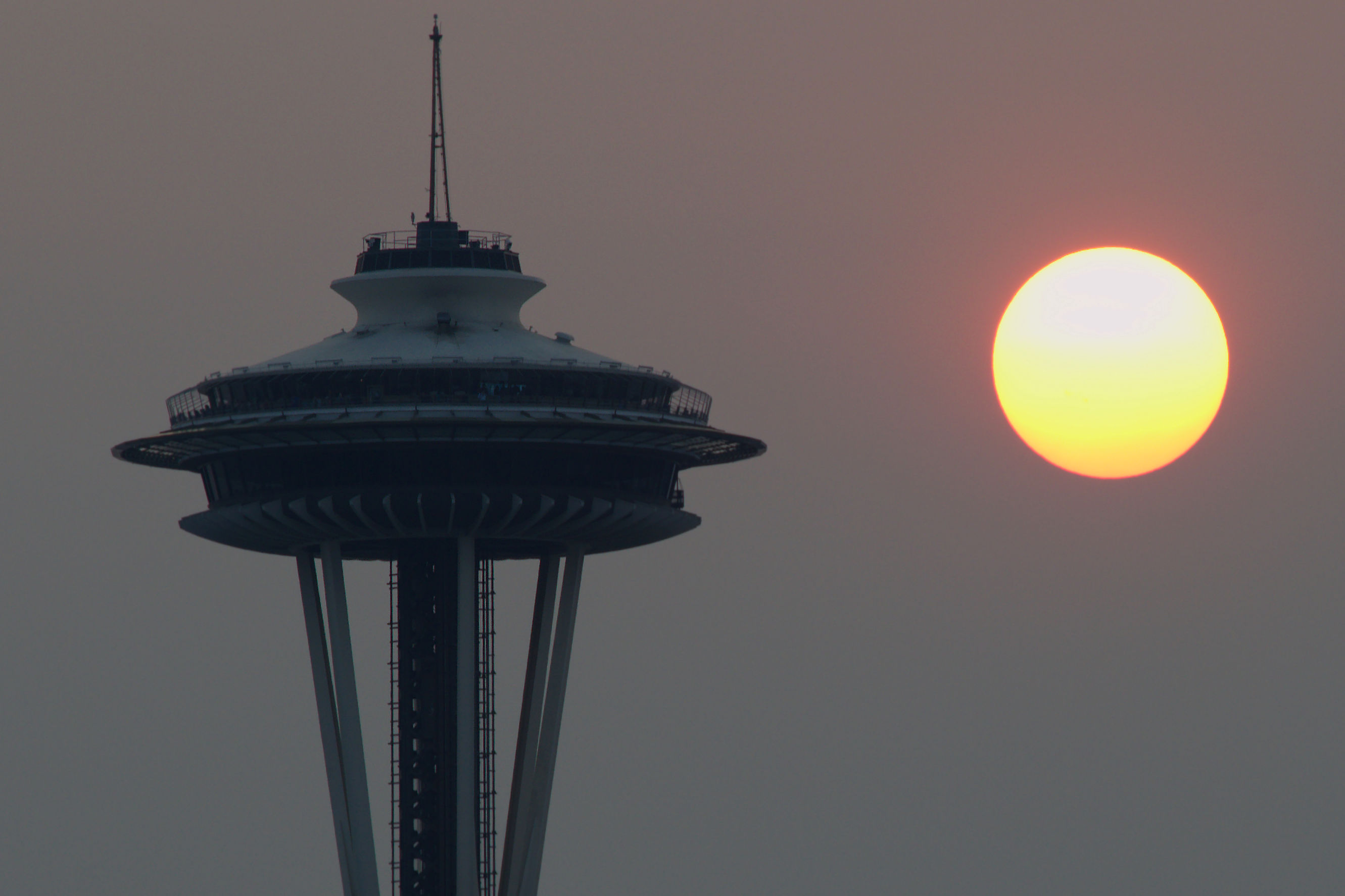 caption: Smoke fills the horizon over Seattle, contributing to a hazy sunset on Saturday, Aug. 22, 2015.