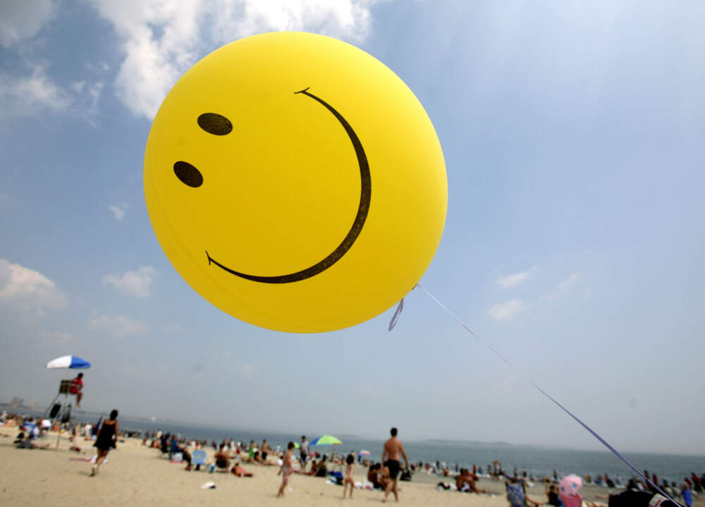 caption: A smiley face balloon floats over Revere Beach in Revere, Mass. (Michael Dwyer/AP)