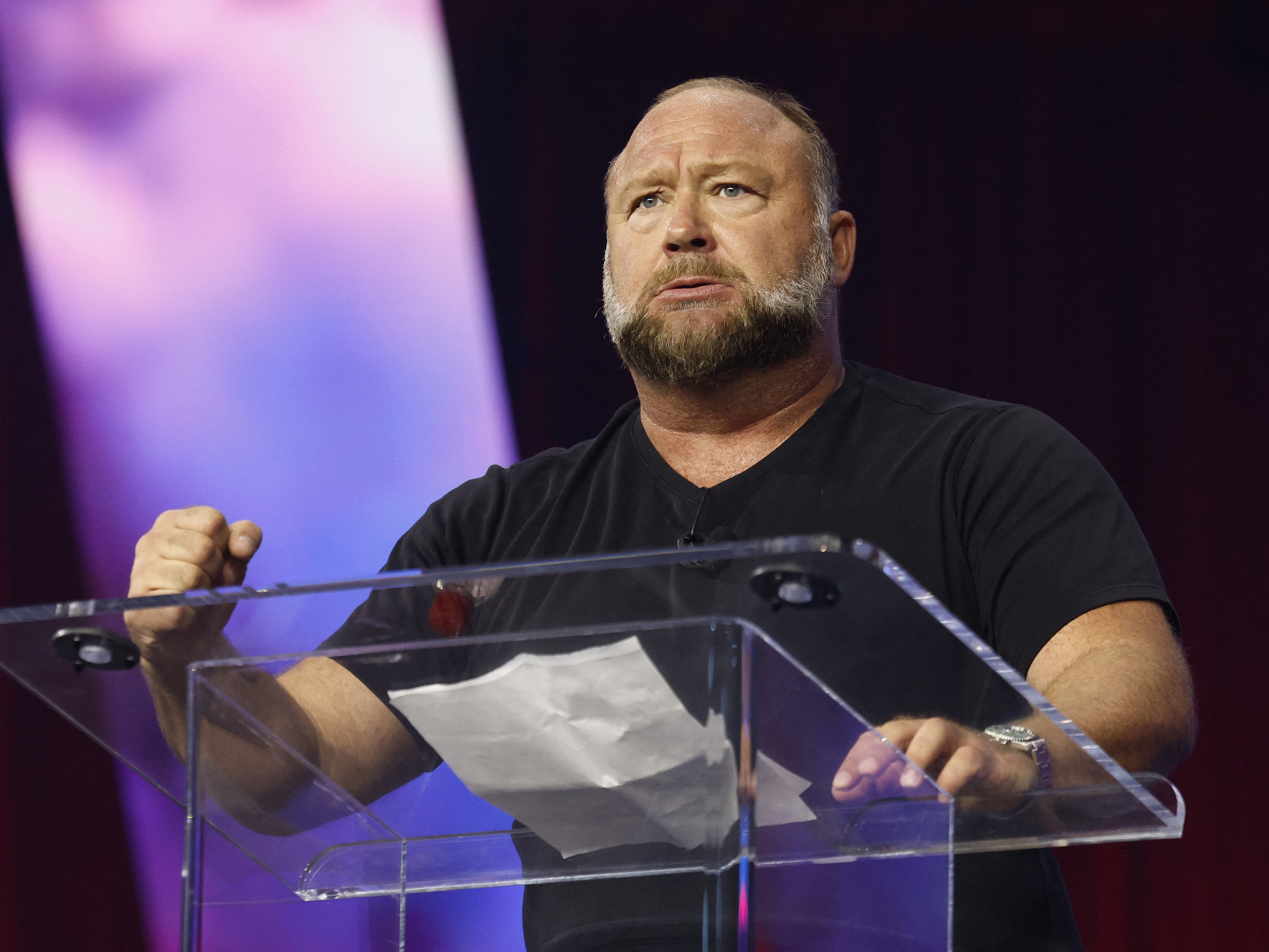 caption: Infowars host Alex Jones addresses the conservative Turning Point People's Convention earlier this month at Huntington Place in Detroit. 