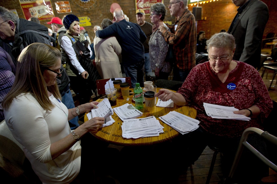 caption: In this Jan. 25, 2016, photo, volunteers sort through commitment to caucus for Democratic presidential candidate Hillary Clinton cards during a campaign event at the Smokey Row in Oskaloosa, Iowa.