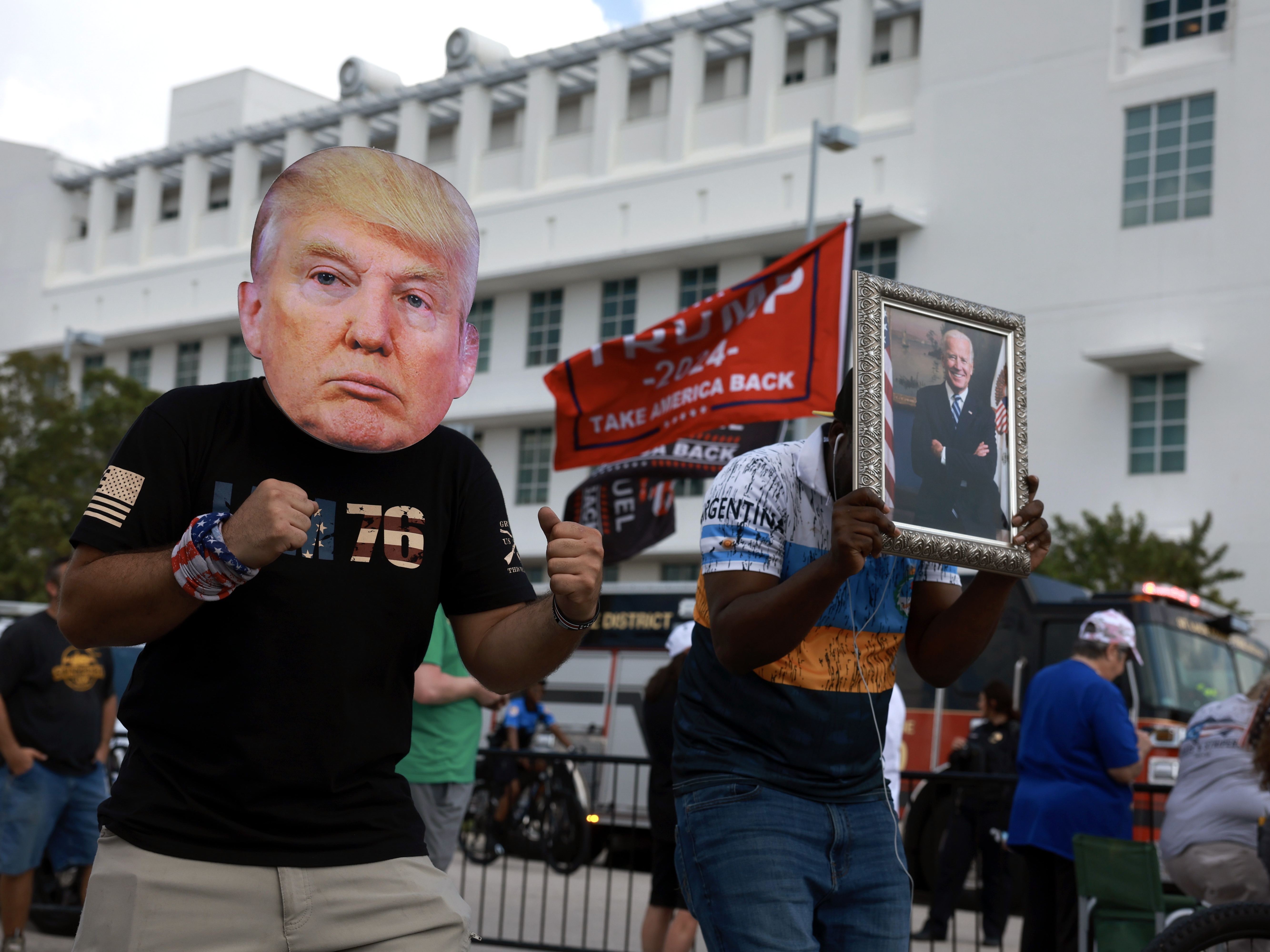 caption: A man wears a mask of former President Donald Trump in front of a Fort Pierce, Fla., courthouse.
