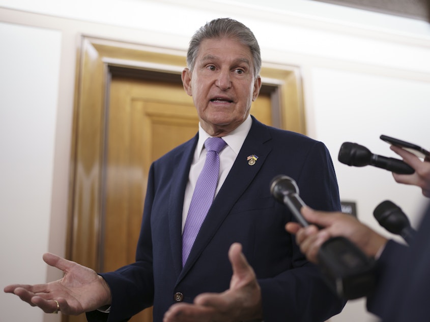 caption: Sen. Joe Manchin, D-W.Va., is met by reporters outside the hearing room where he chairs the Senate Committee on Energy and Natural Resources, at the Capitol in Washington, D.C., last week.