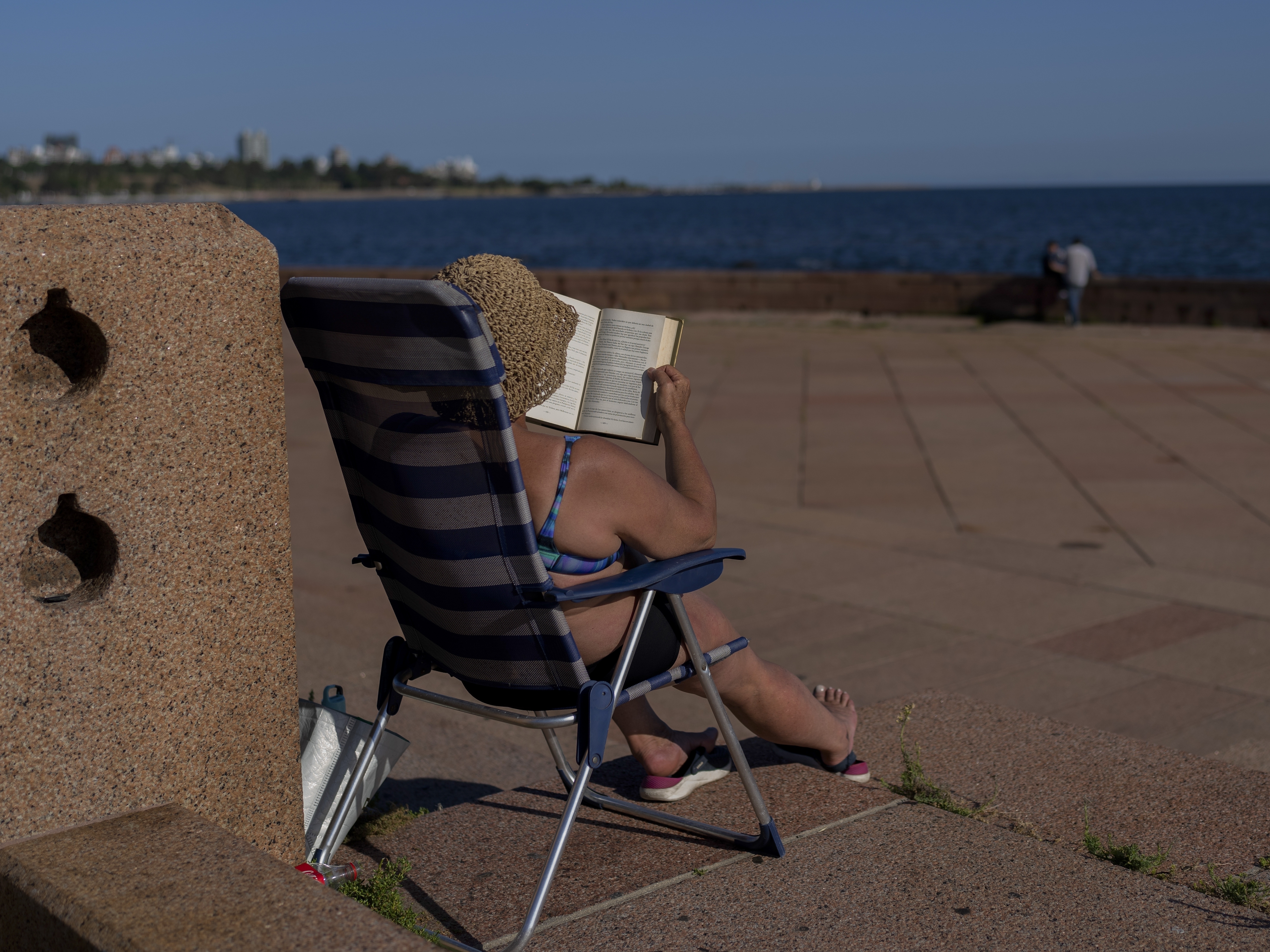caption: A woman sunbathes on a summer day in Montevideo, Uruguay, in January of 2025. This January was the hottest ever recorded on Earth.