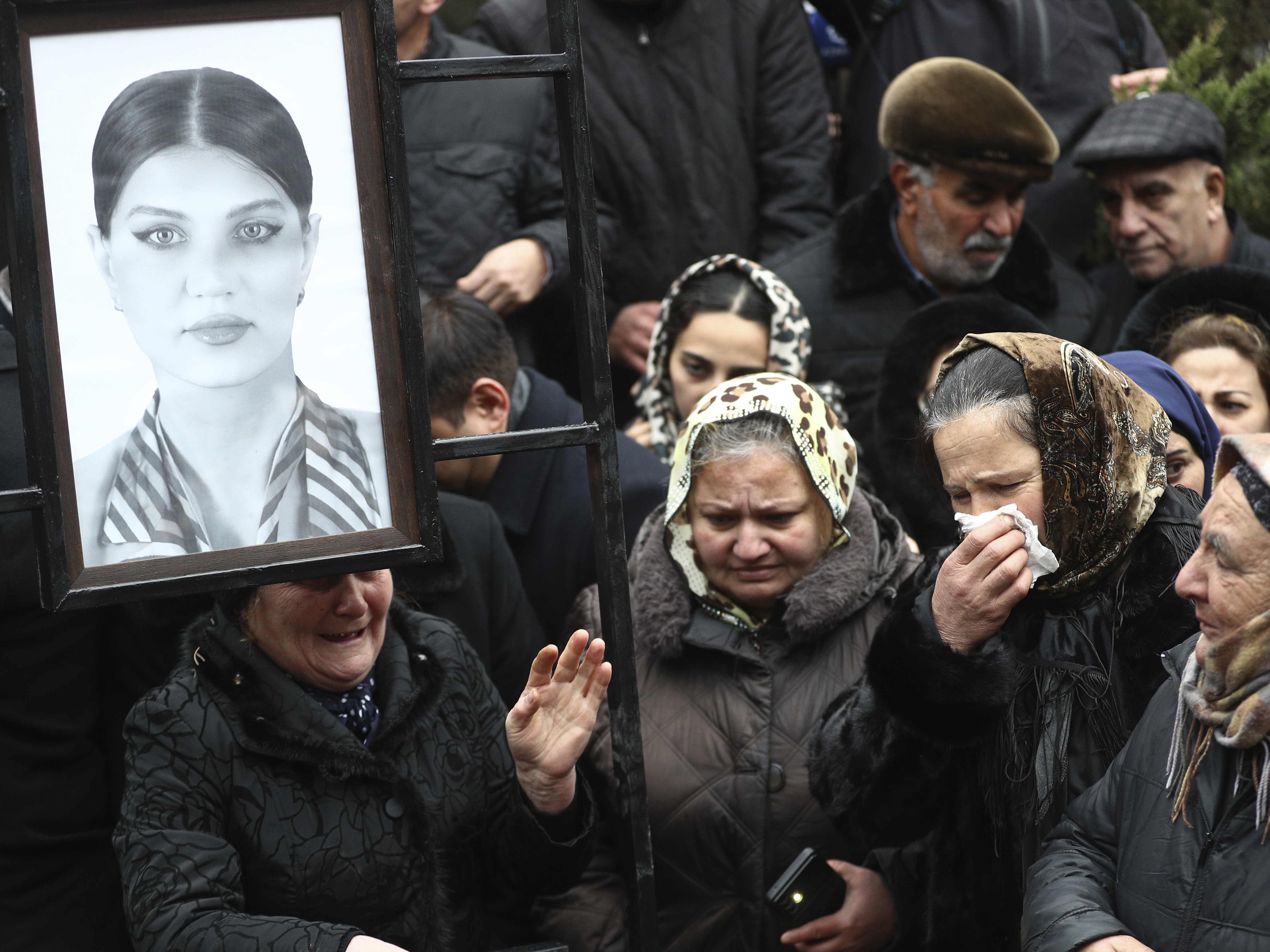 caption: People mourn at the grave of flight attendant Hokume Aliyeva during a funeral of the crew members of the Azerbaijan Airlines Embraer 190 killed in a deadly plane crash in Kazakhstan this week, at the II Alley of Honor in Baku, Azerbaijan, Sunday, Dec. 29, 2024.