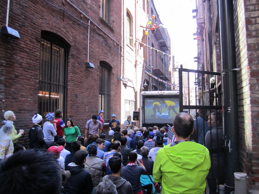 caption: Seattle soccer fans watch a World Cup match in Nord Alley. 