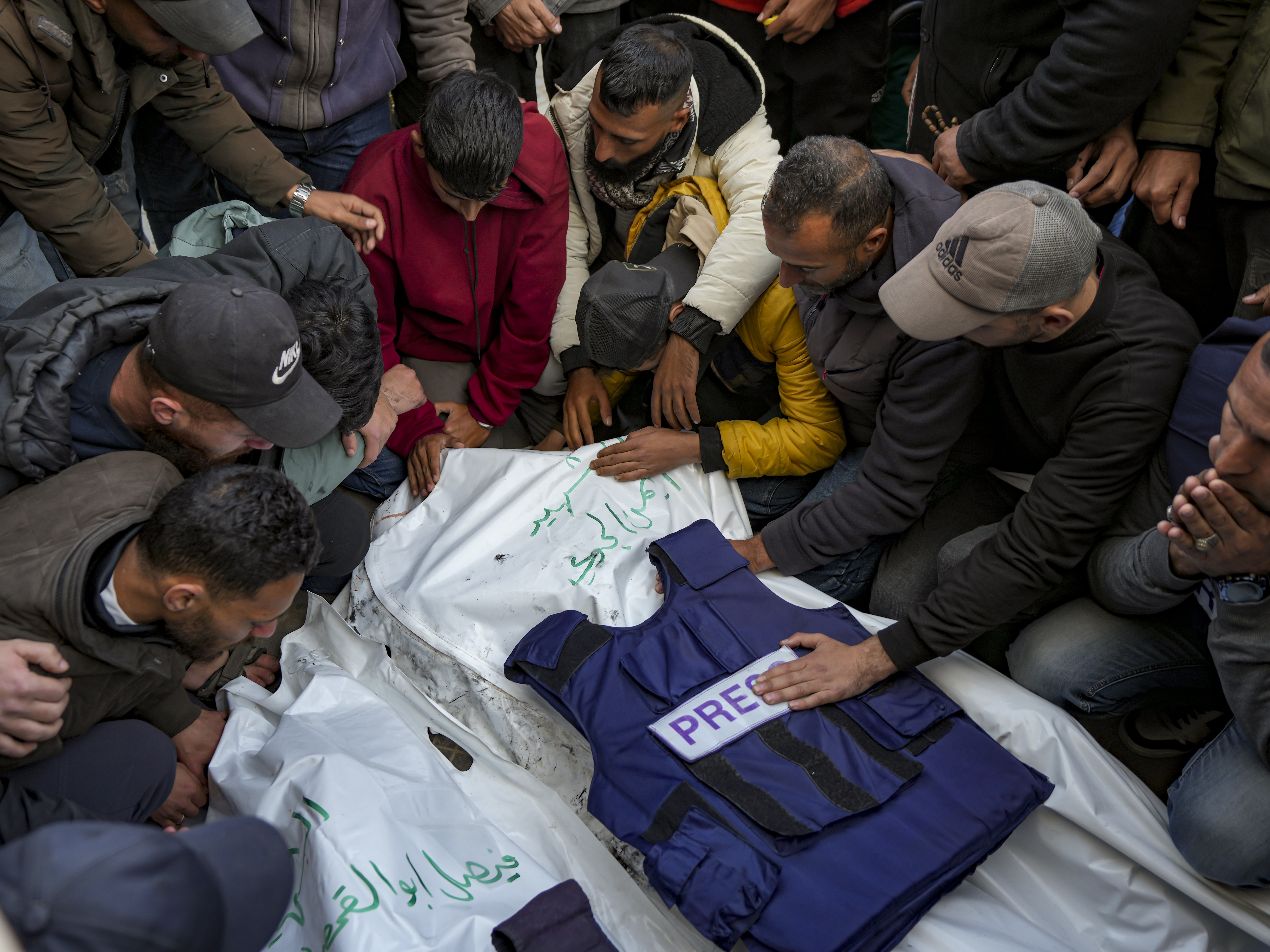 caption: Relatives and friends mourn over the bodies of five Palestinian journalists who were killed by an Israeli airstrike in Gaza City at the Al-Aqsa Hospital in Deir al-Balah, on Thursday.