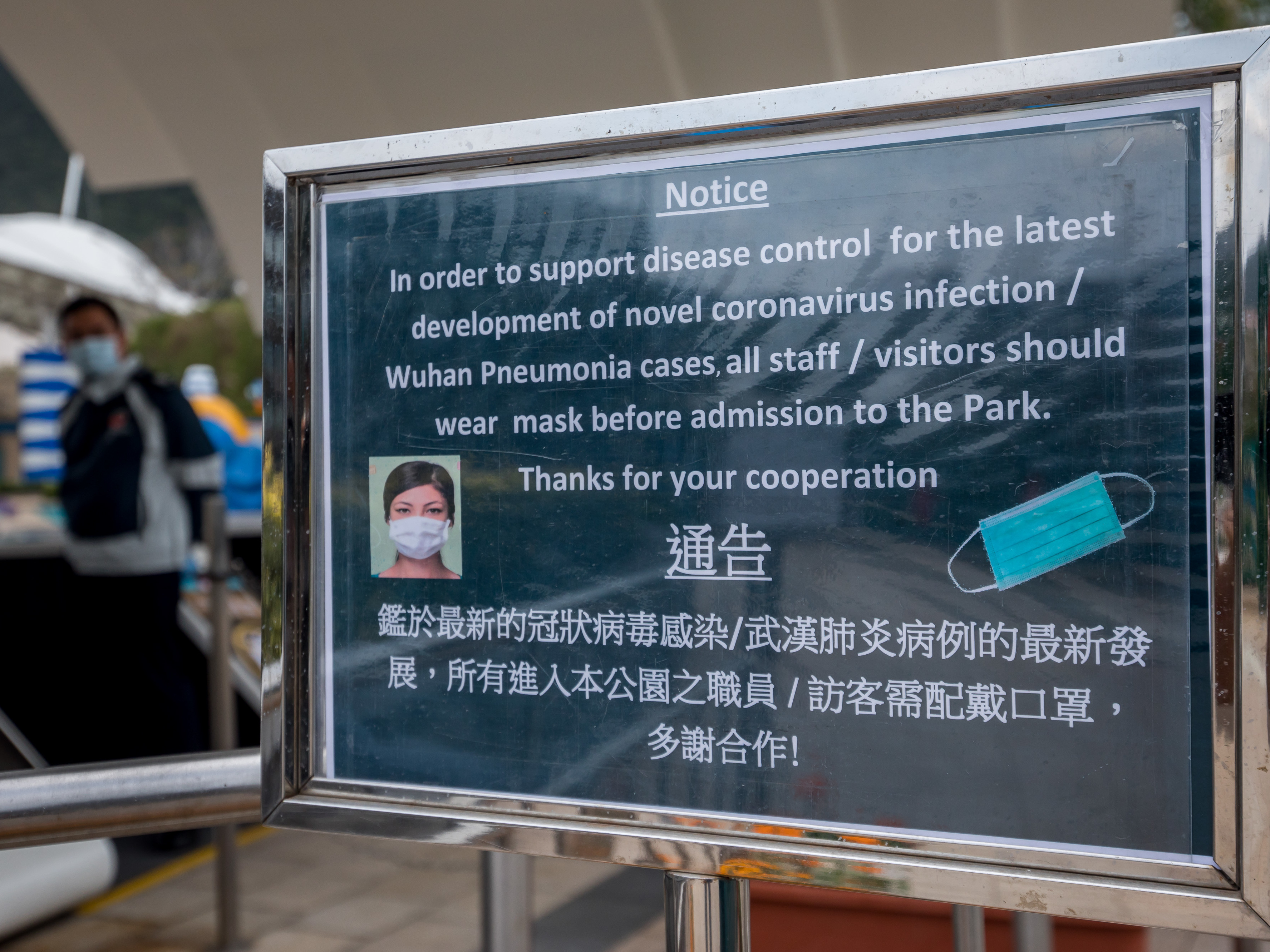 caption: A notice advising all staff and visitors to wear protective masks stands outside the closed Ocean Park in Hong Kong on Monday.