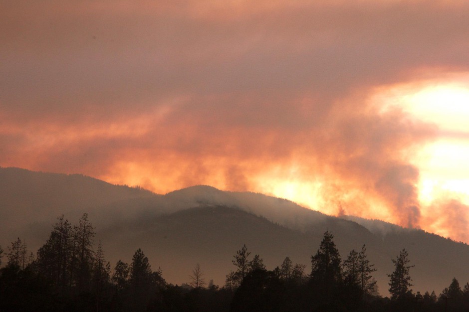 caption: The smoke of the Taylor Creek Fire still plumes behind the Joint Information Center, just outside of Grants Pass, OR.CREDIT: USFS/DARREN STEBBINS