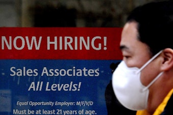caption: A man walks past a "Now Hiring" sign in front of a store in early December in Arlington, Va. U.S. employers added 379,000 jobs in February, as hiring picked up sharply from the previous month.