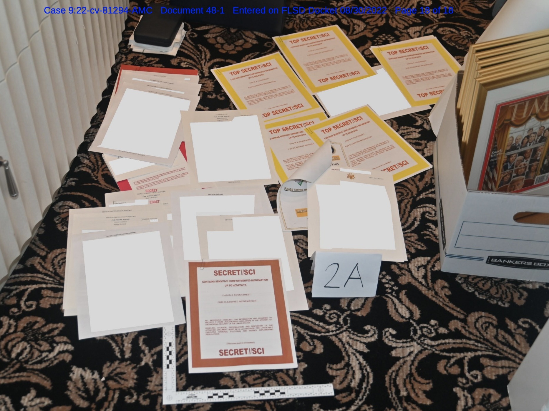 caption: The FBI photographed documents marked "Top Secret" on the floor of former President Trump's office in Mar-a-Lago, Fla. The redacted image was included in a Justice Department filing.