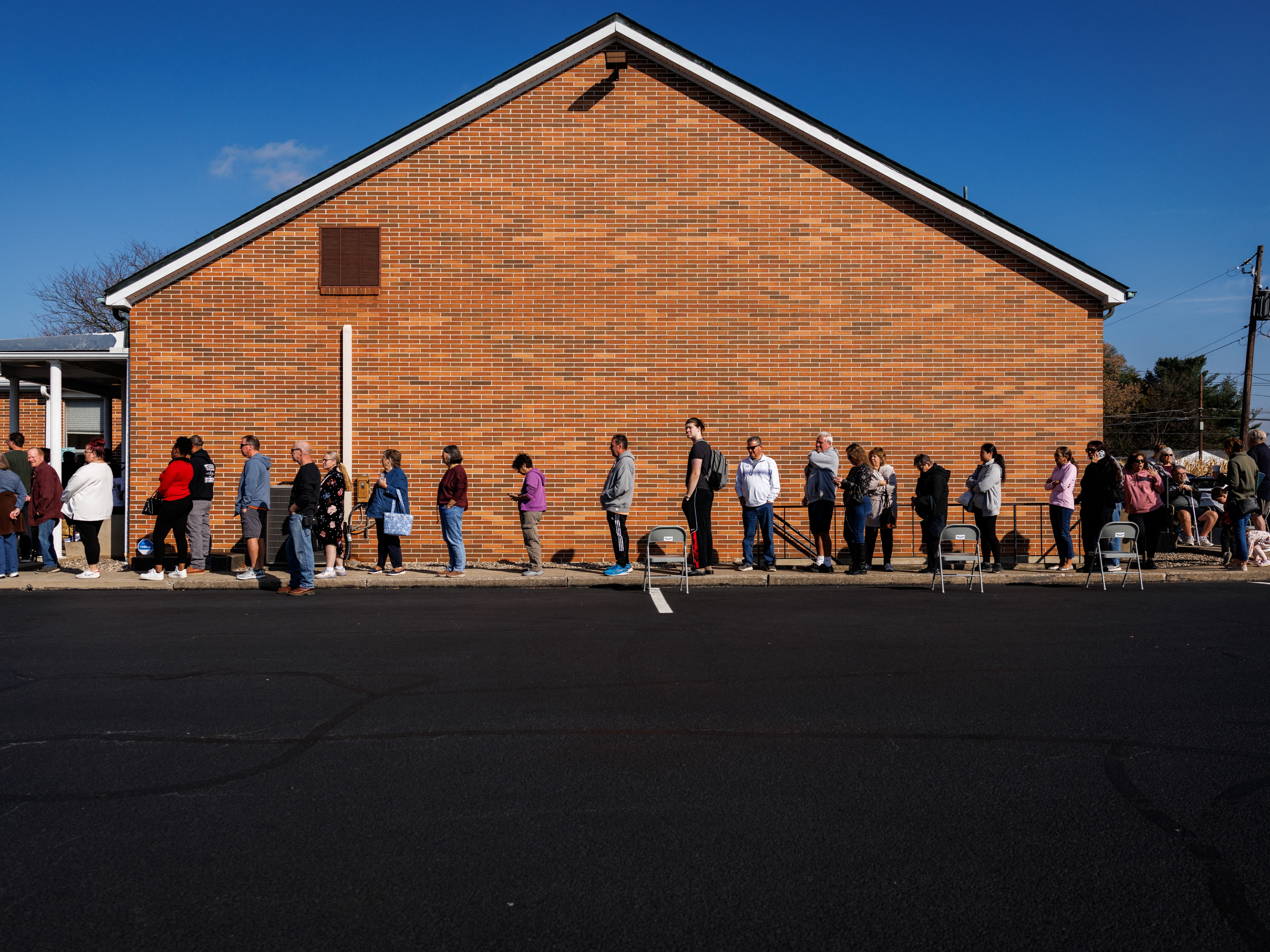 caption: People wait in line to vote outside a polling station at the Dryland United Church of Christ in Nazareth, Pa., on Tuesday.