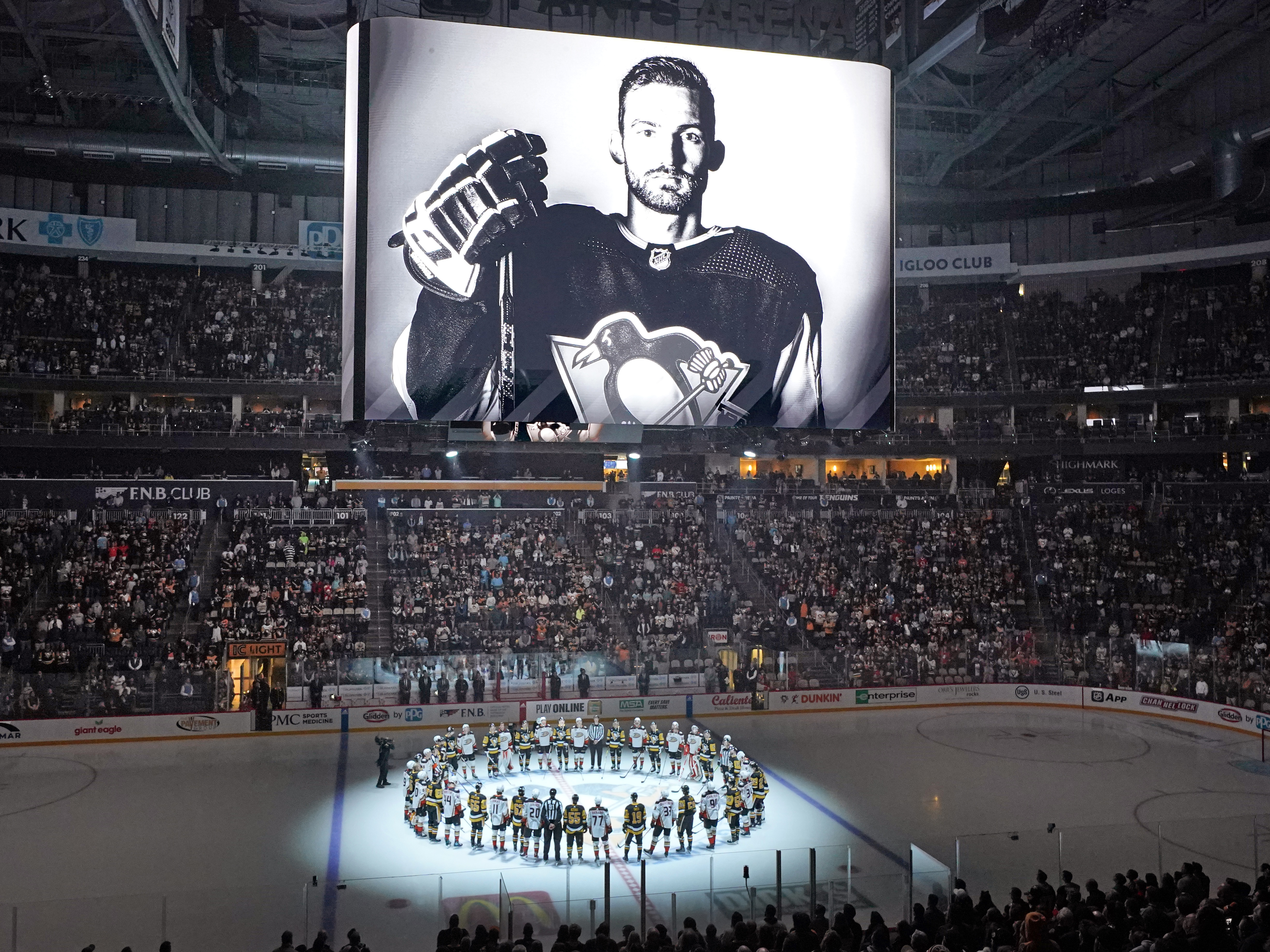 caption: Players from the Pittsburgh Penguins and Anaheim Ducks on Monday honored former Penguin player Adam Johnson, who died during a game in England. The Penguins are making neck guards mandatory for players at the minor-league level, and will also urge NHL players to wear them.