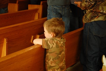 caption: A young boy attends a Sunday church service at the First Baptist Church in Darrington, Wash., a week after the devastating Oso mudslide.