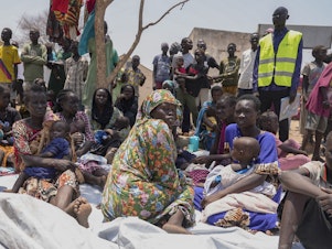 caption: South Sudanese who fled from Sudan sit outside a nutrition clinic at a transit center in Renk, South Sudan, May 16, 2023. Fighting in Sudan has displaced 10 million people, according to U.N. figures.