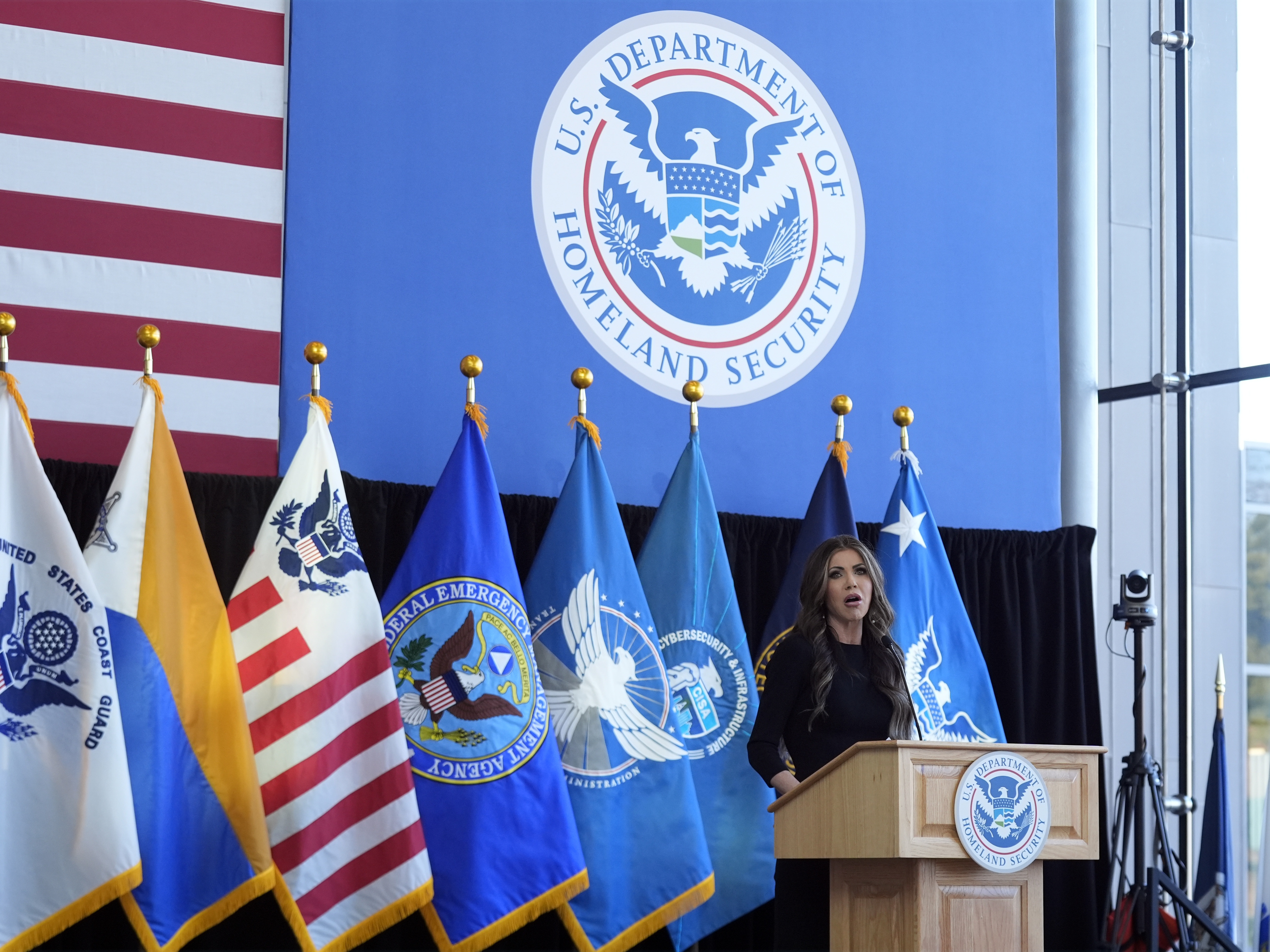 caption: Homeland Security Secretary Kristi Noem speaking at the Department of Homeland Security headquarters in January 2025.