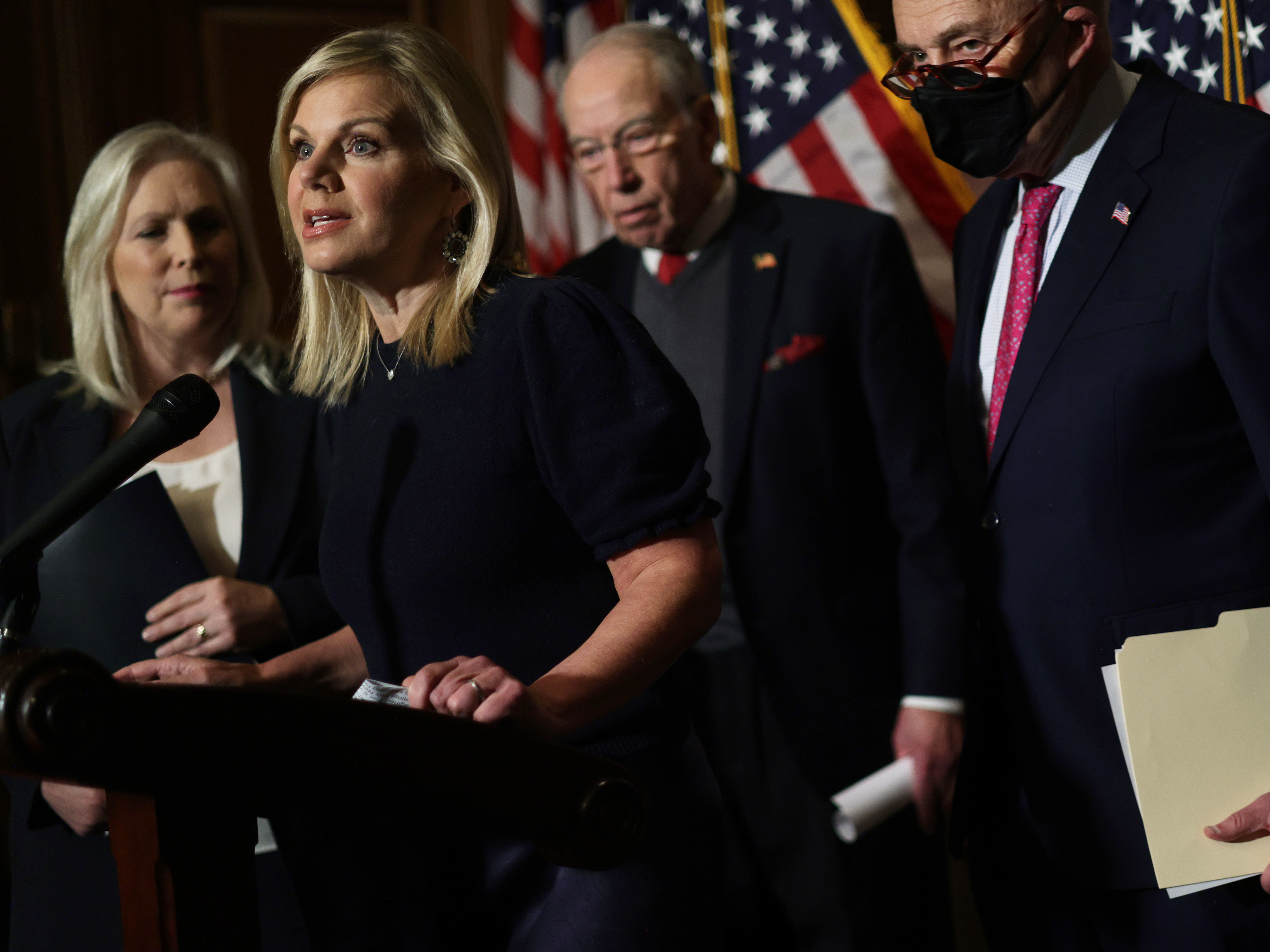 caption: Former Fox News anchor Gretchen Carlson speaks as (L-R) U.S. Sen. Kirsten Gillibrand (D-NY), Sen. Chuck Grassley (R-IA) and Senate Majority Leader Sen. Chuck Schumer (D-NY) look on after passage of the Ending Forced Arbitration of Sexual Assault and Sexual Harassment Act.