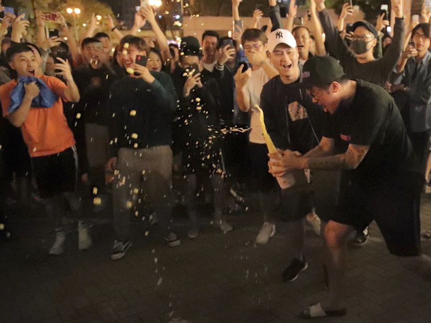 caption: Pro-democracy supporters celebrate after pro-Beijing politician Junius Ho lost his election in Hong Kong, early Monday, Nov. 25, 2019.