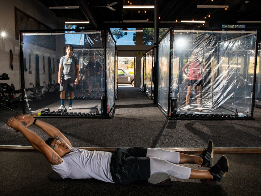 caption: Peet Sapsin directs clients inside custom built "Gainz Pods", during his HIIT class, (high intensity interval training), at Sapsins Inspire South Bay Fitness, Redondo Beach, California, Wednesday, June 17, 2020.
