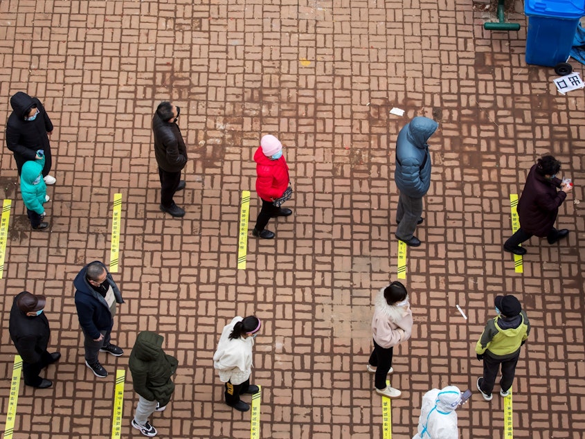 caption: Residents queue to undergo tests for the coronavirus in China's northeastern Jilin province on Saturday.