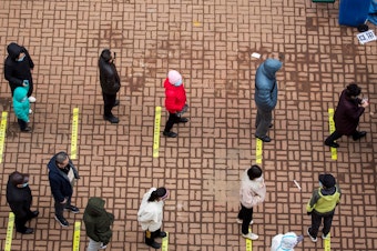 caption: Residents queue to undergo tests for the coronavirus in China's northeastern Jilin province on Saturday.
