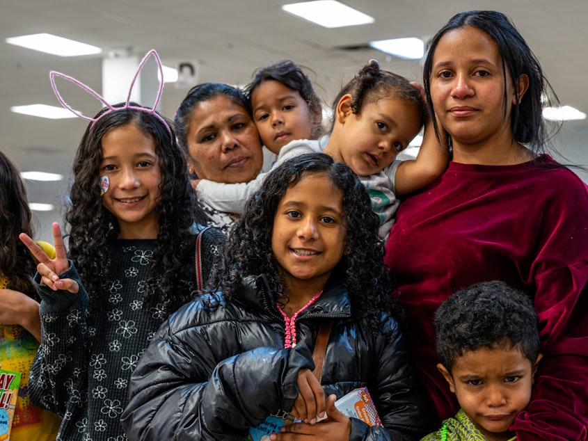 caption: Yajaíra Peñaloza (left) and Marian Araujo pose with their children while waiting for their ride at the Casa Alitas shelter in Tucson, Ariz., on March 26.