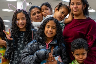 caption: Yajaíra Peñaloza (left) and Marian Araujo pose with their children while waiting for their ride at the Casa Alitas shelter in Tucson, Ariz., on March 26.