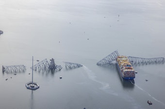 caption: An aerial view of the cargo ship Dali after it ran into and collapsed the Francis Scott Key Bridge on March 26, 2024 in Baltimore, Maryland.
