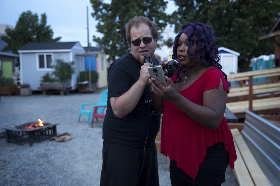caption: Travis, left, and Ciara, right, sing Summer Lovin' during karaoke on Sunday, June 9, 2019, at the Georgetown Tiny House Village in Seattle.