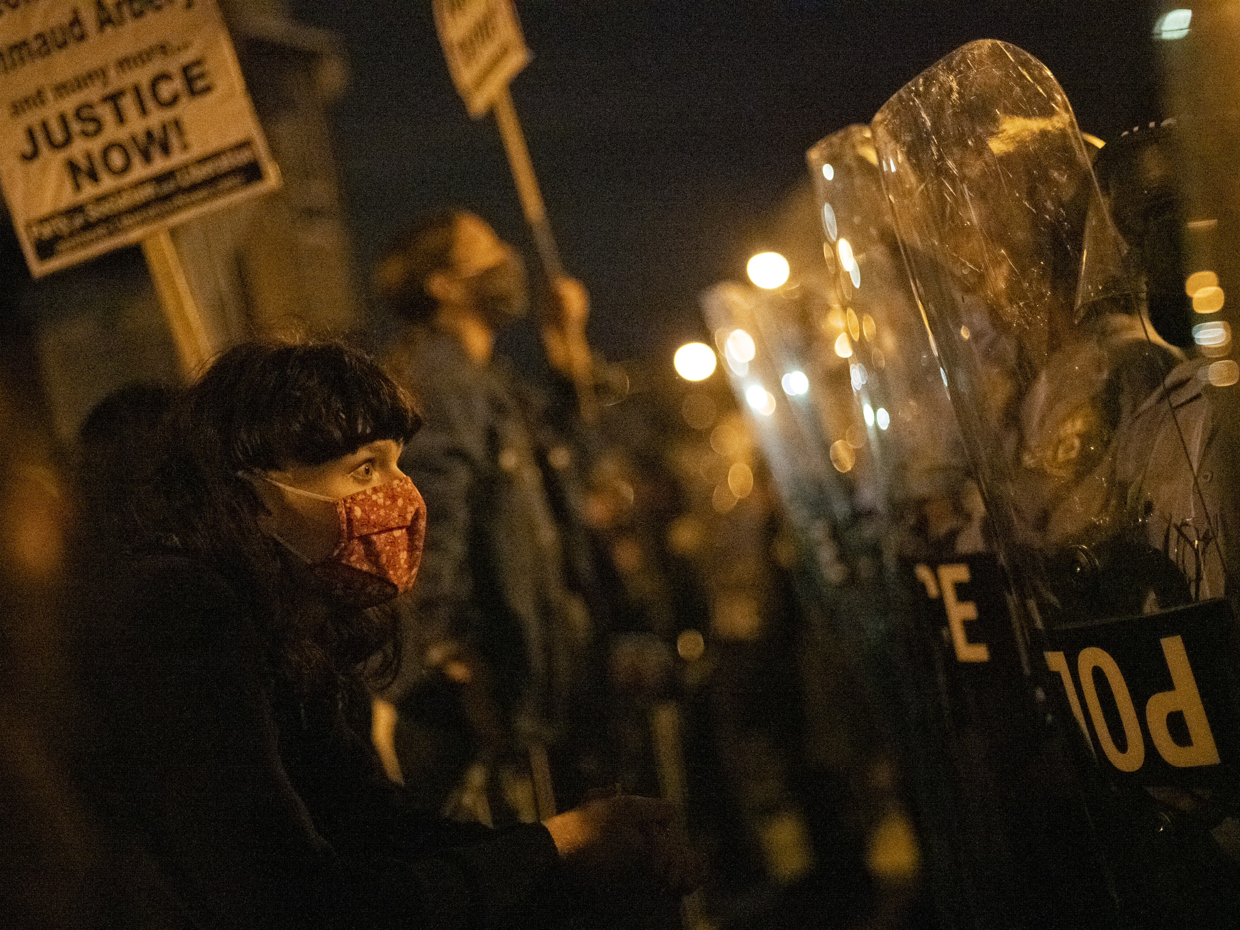 caption: A demonstrator confronts police officers during a protest against the shooting of 27-year-old Walter Wallace.