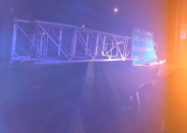 caption: A large highway sign lies across the median on state Route 520 after a construction crane knocked it down late Tuesday night. The sign struck a bus, injuring several people.