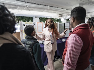 caption: At the National STEM Festival, 12th-grader Treyonna Sullivan talks with visitors about her "Project Poop," created to encourage pet owners in her community to dispose of their pet's waste.