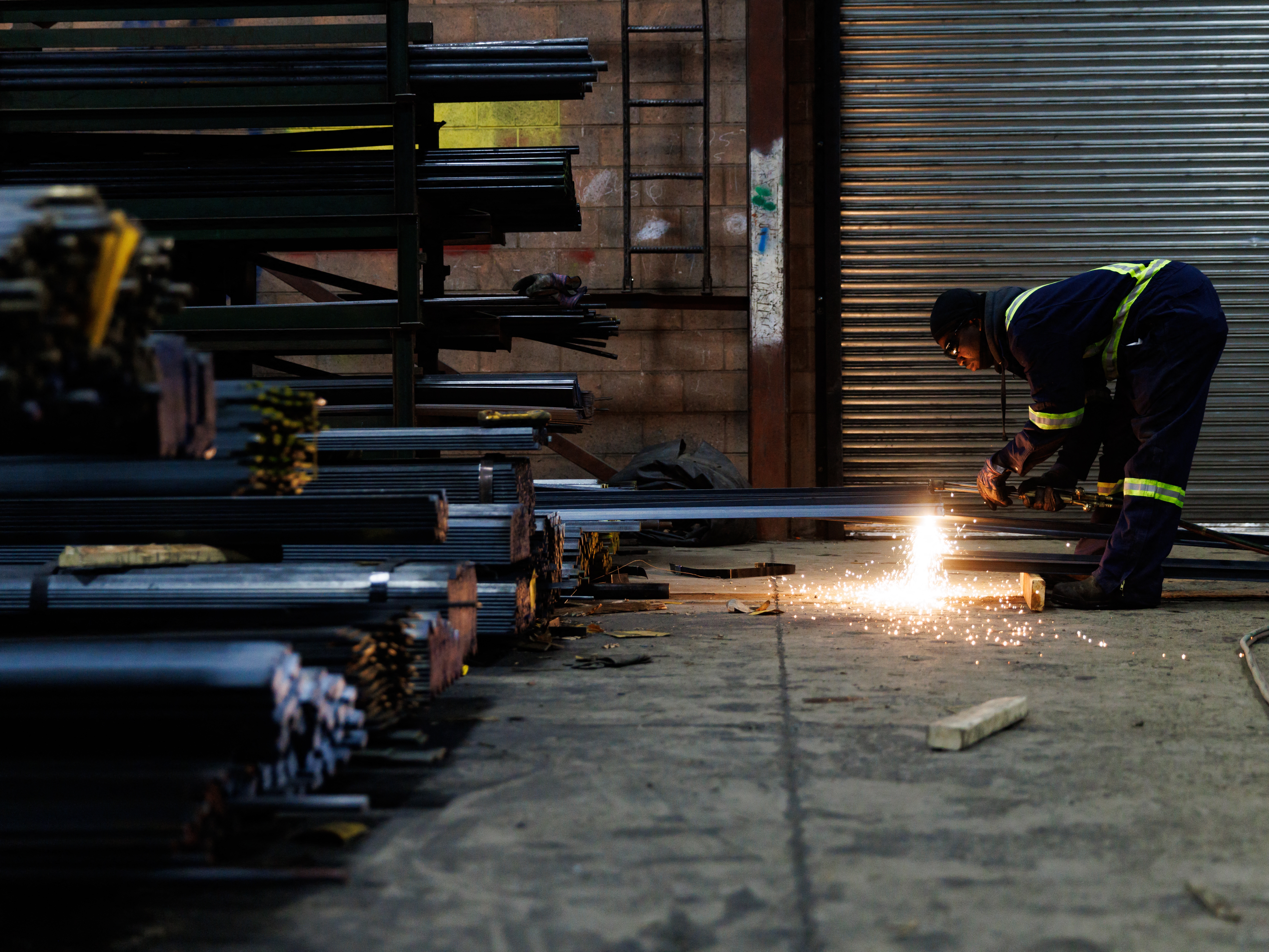 caption: A worker cuts a piece of steel for a customer at North York Iron, a steel supplier in Toronto, Ontario, Canada, Feb. 11.