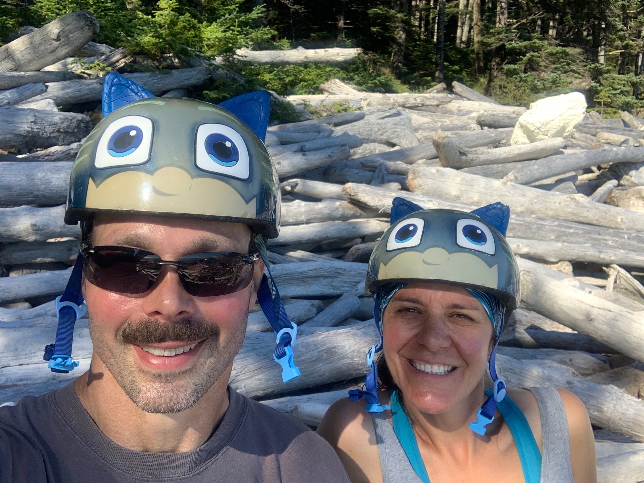 caption: Kurt Whitehead and Trina Nation model kids' bike helmets they found beachcombing on Noyes Island, Alaska, in August.