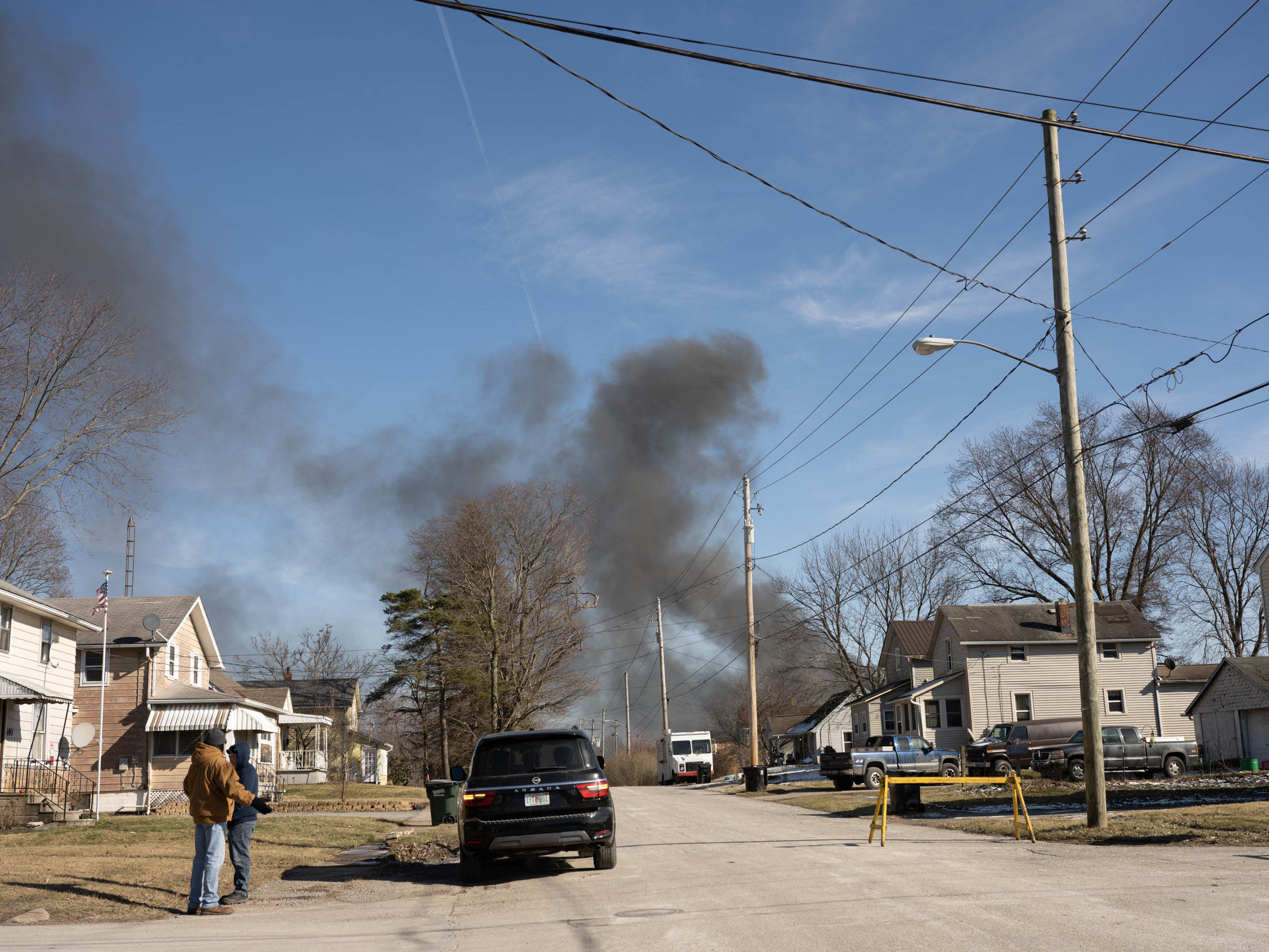 caption: Smoke rises from a derailed cargo train in East Palestine, Ohio, on Feb. 4.