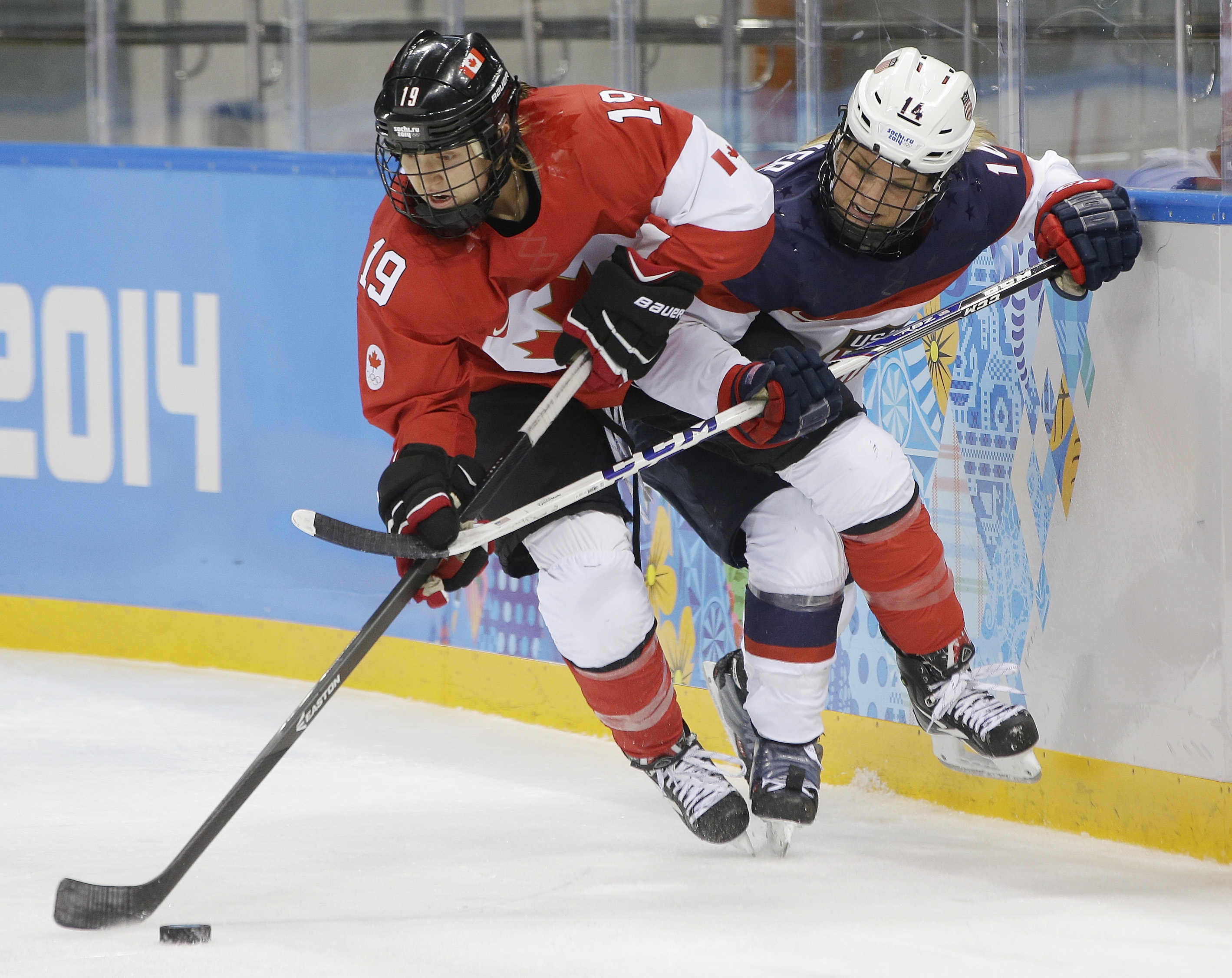 caption: Brianne Jenner of Canada and Brianna Decker of the United States battle for control of the puck during the second period of the 2014 Winter Olympics women's ice hockey game on February 12, 2014, in Sochi, Russia.