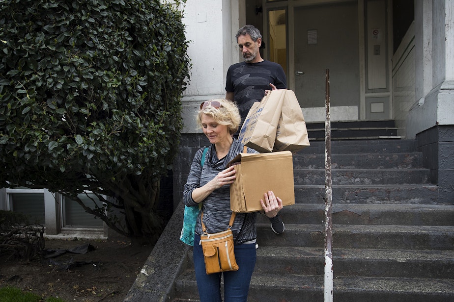 caption: Jerri and Matt Clark carry the last of their son Calvin's belongings out of his apartment building on Friday, March 22, 2019, in Seattle.