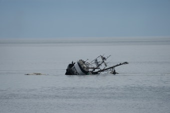caption: Members of the crew stand near the starboard rail as the Aleutian Isle sinks off San Juan Island on August 14.